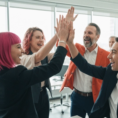 Diverse team celebrating a milestone with high-fives and smiles